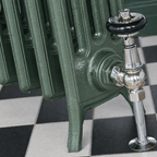 Green smoke cast iron radiator with chrome valve on a checkered floor